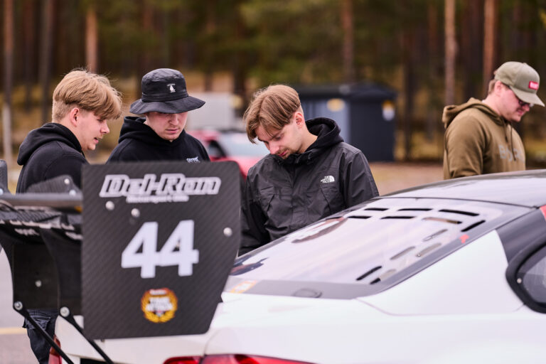 Kuljettajat auton numero 44 äärellä varikolla